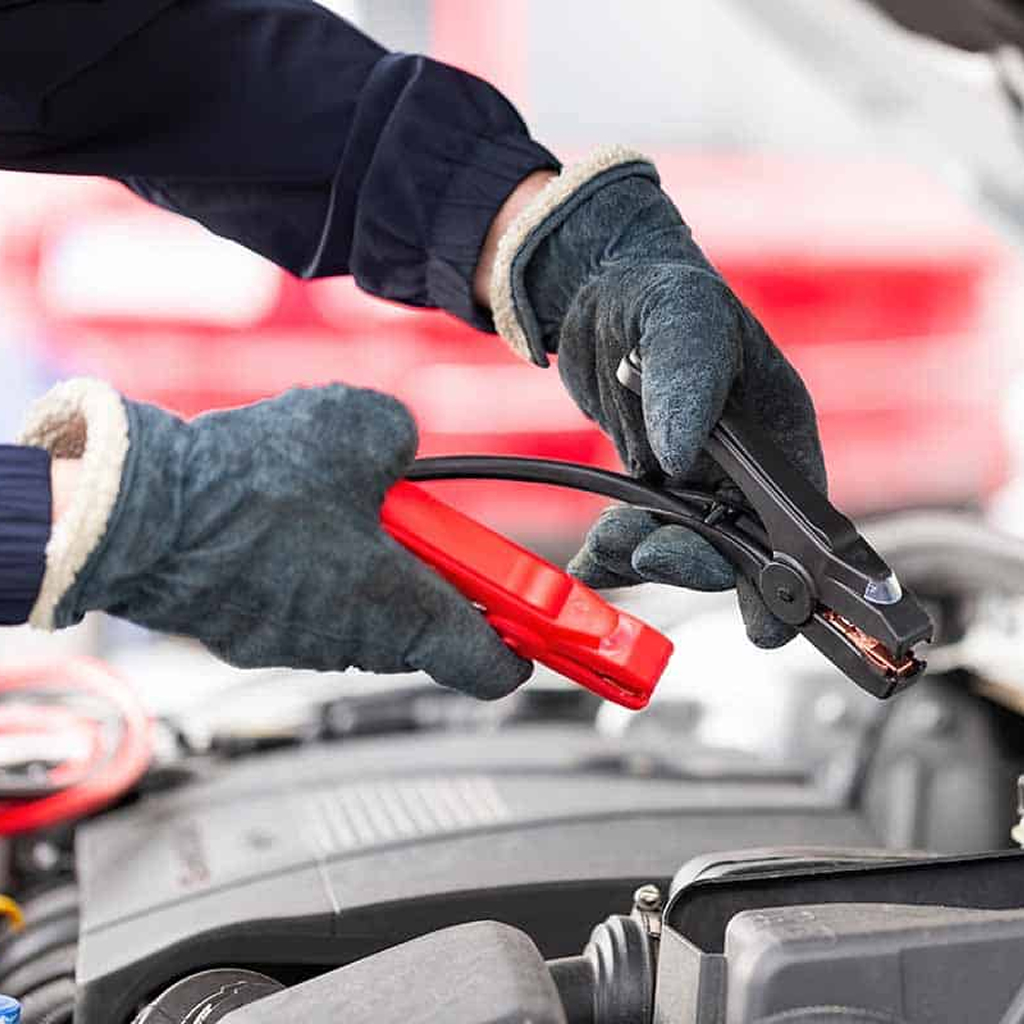 photo shows Dynamic Truck & Trailer Repair & Towing tech putting jumpstarting a vehicle 