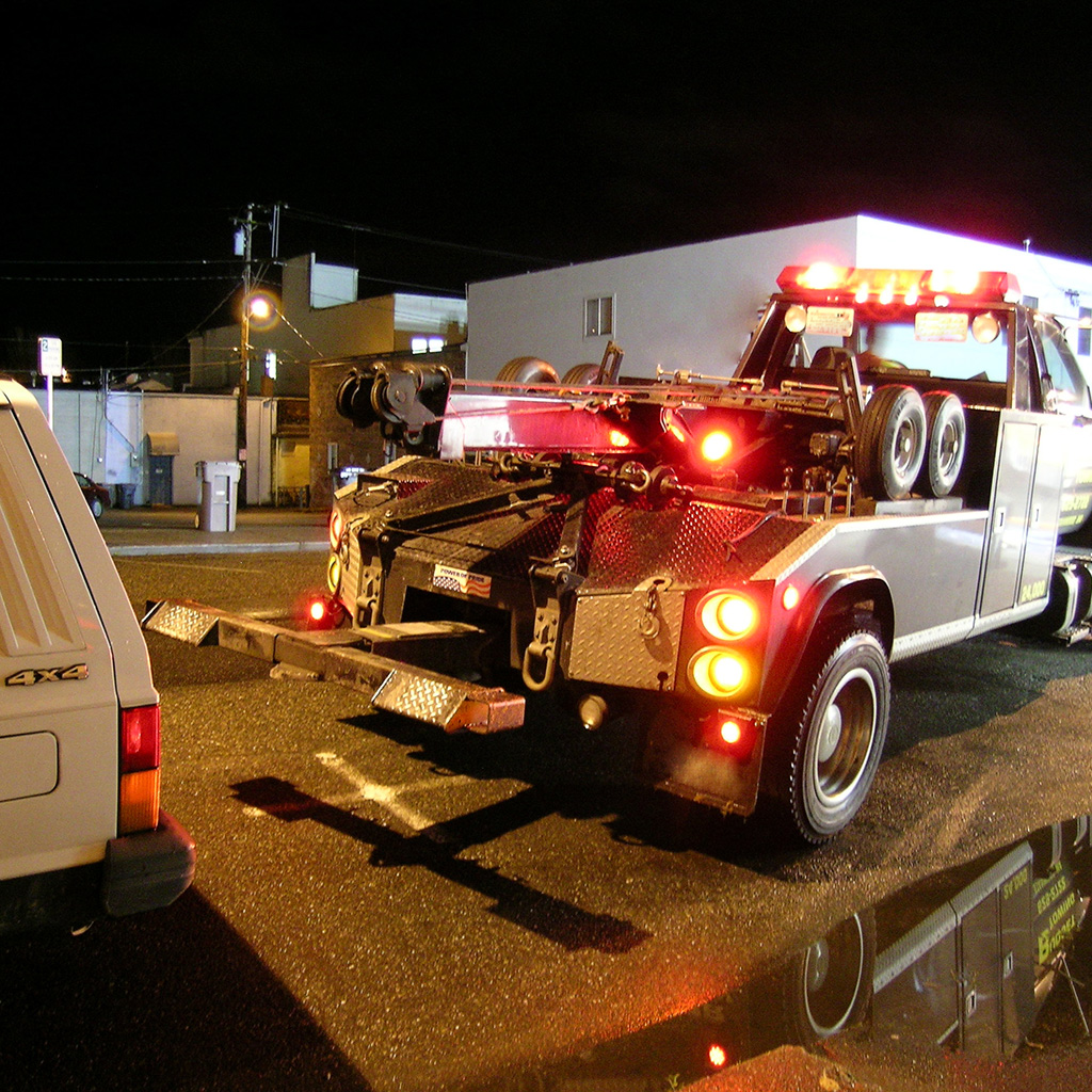 photo of Dynamic Truck & Trailer Repair & Towing flat bed truck with pickup truck on back showing light towing