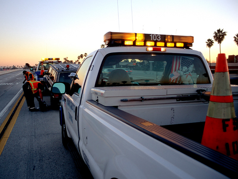 photo shows Dynamic Truck & Trailer Repair & Towing tech changing a car tire on side of the road
